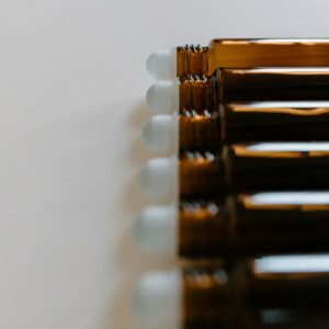 A line of amber glass roll-on bottles on a soft white background, perfect for essential oils.